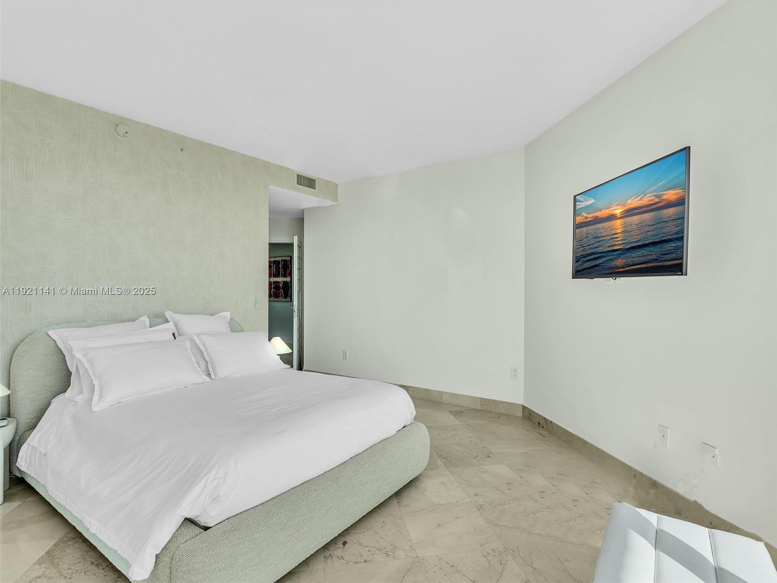 16500 Collins Avenue, Unit PH54 Sunny Isles Beach, FL 33160 - Photo 67 of 97 a bedroom with a bed and wall painting