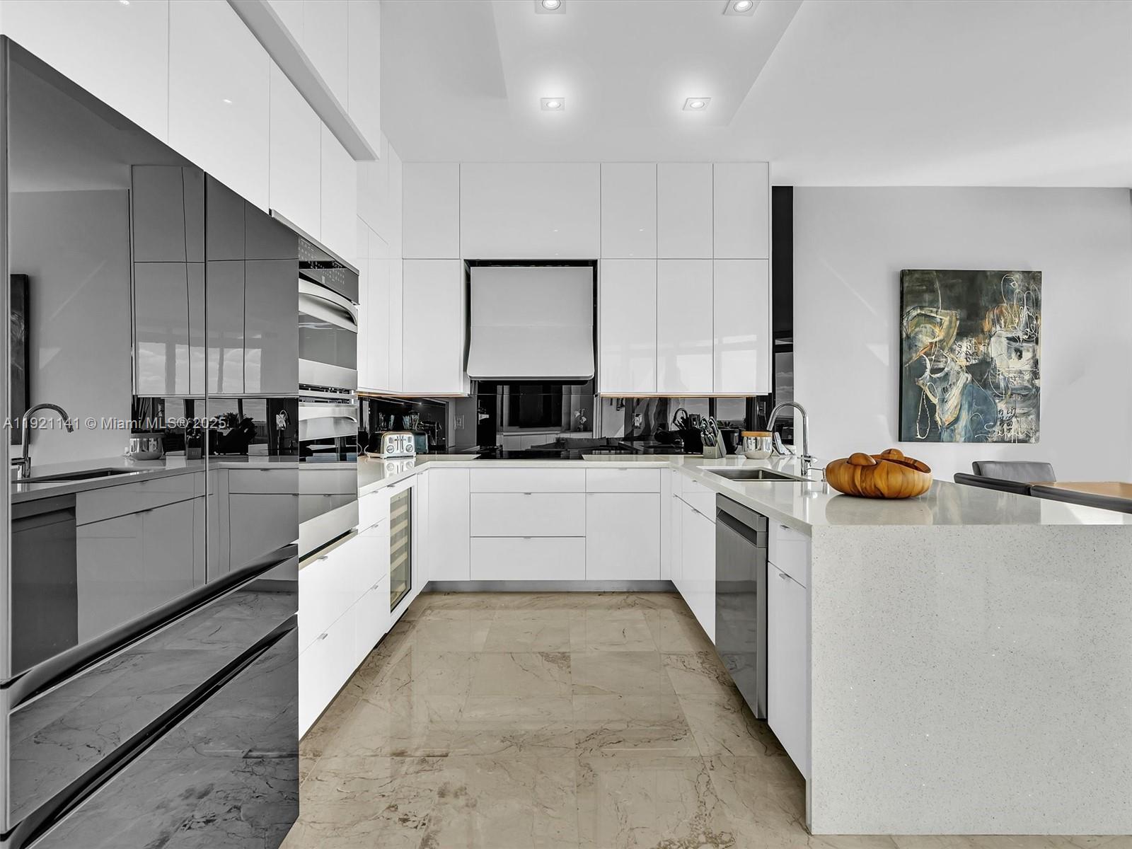 16500 Collins Avenue, Unit PH54 Sunny Isles Beach, FL 33160 - Photo 7 of 97 a large white kitchen with stainless steel appliances