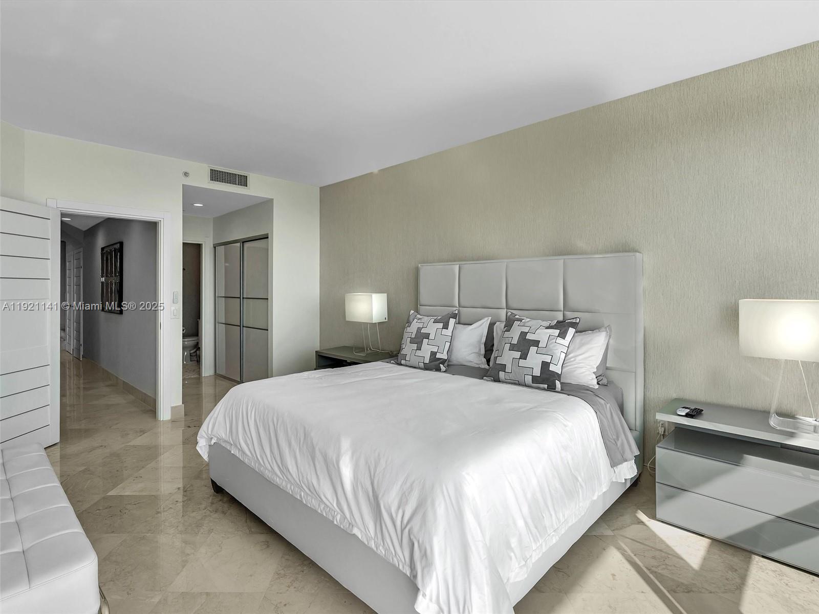 16500 Collins Avenue, Unit PH54 Sunny Isles Beach, FL 33160 - Photo 75 of 97 a bedroom with a bed and a lamp