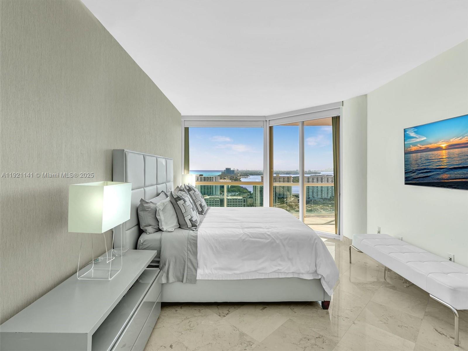 16500 Collins Avenue, Unit PH54 Sunny Isles Beach, FL 33160 - Photo 77 of 97 a large bedroom with a bed and large window