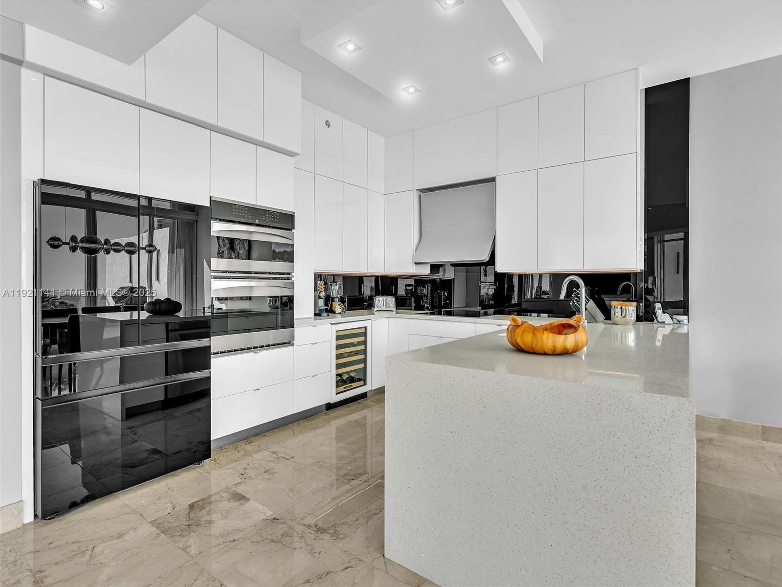 16500 Collins Avenue, Unit PH54 Sunny Isles Beach, FL 33160 - Photo 9 of 97 a kitchen with stainless steel appliances a stove a sink and a refrigerator