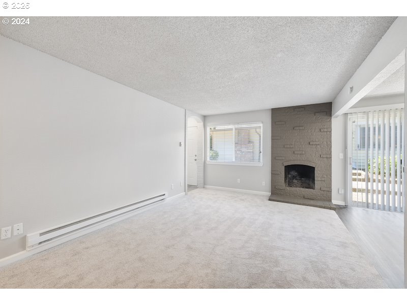 2921 Northeast Rene Avenue, Unit 15B Gresham, OR 97030 - Photo 4 of 22 a view of an empty room with a fireplace and a window