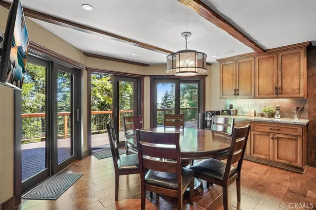 a view of a dining room with furniture a chandelier and wooden floor