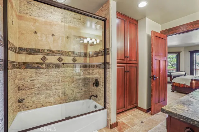 a bed sitting in a spacious bedroom next to a window and a larger closet