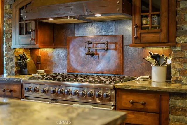a kitchen with stainless steel appliances granite countertop a stove and a wooden floors