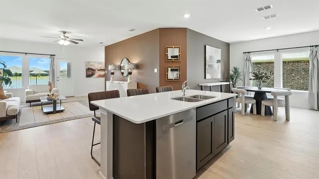 a large kitchen with kitchen island a sink table and chairs