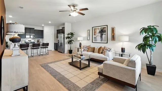 a living room with furniture kitchen view and a potted plant