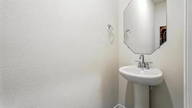 a bathroom with a sink a mirror and a lamp