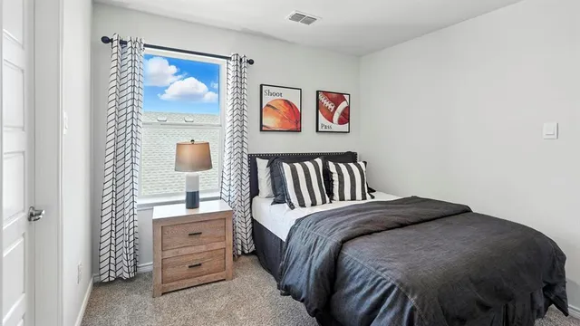 a bedroom with a bed and a painting on the wall