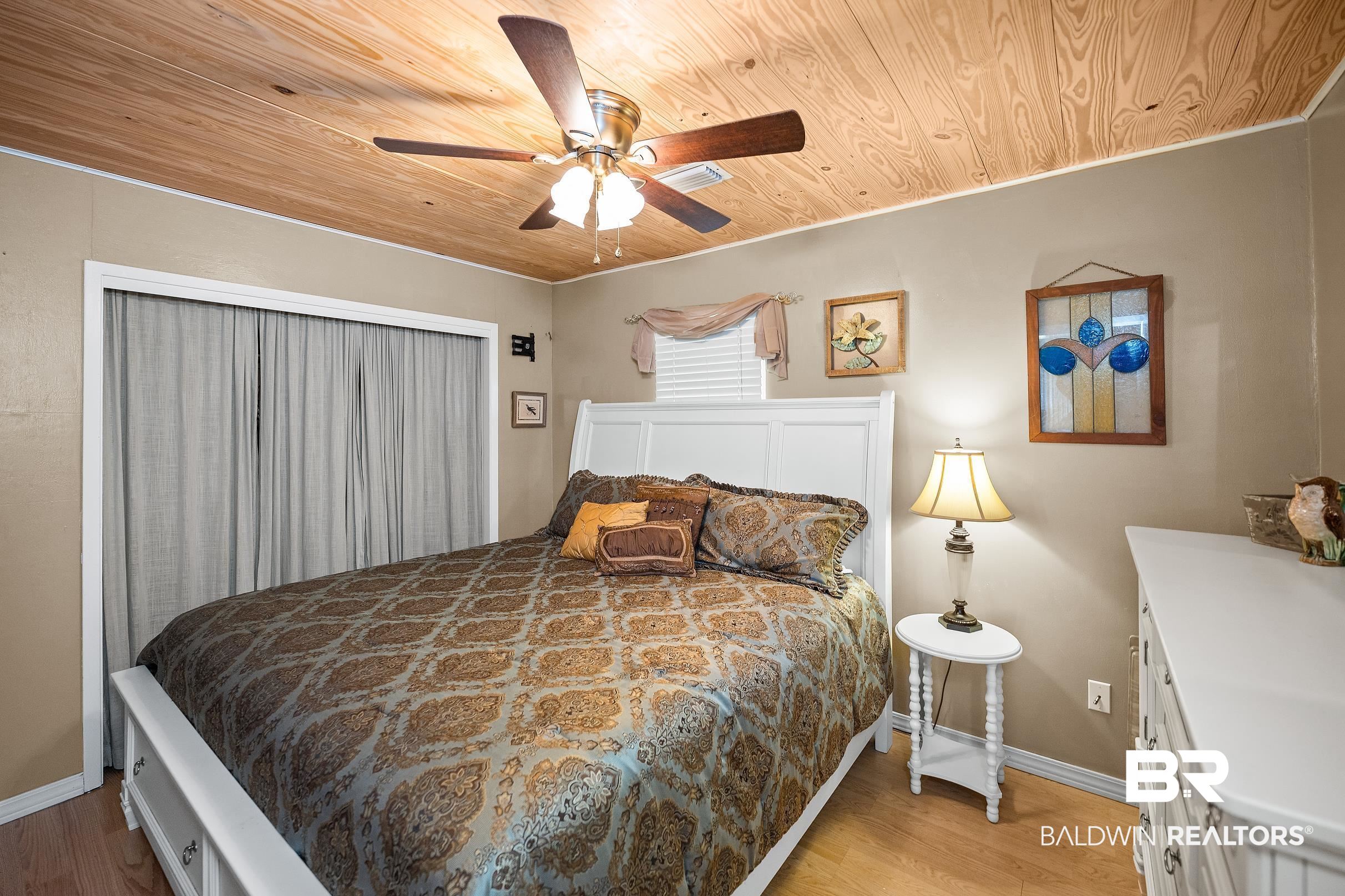 110 Sam Jones Road Atmore, AL 36502 - Photo 22 of 47 Bedroom featuring wooden ceiling, light wood-type flooring, and a ceiling fan