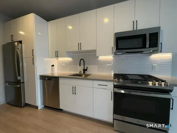 a kitchen with stainless steel appliances a stove a microwave a sink and cabinets