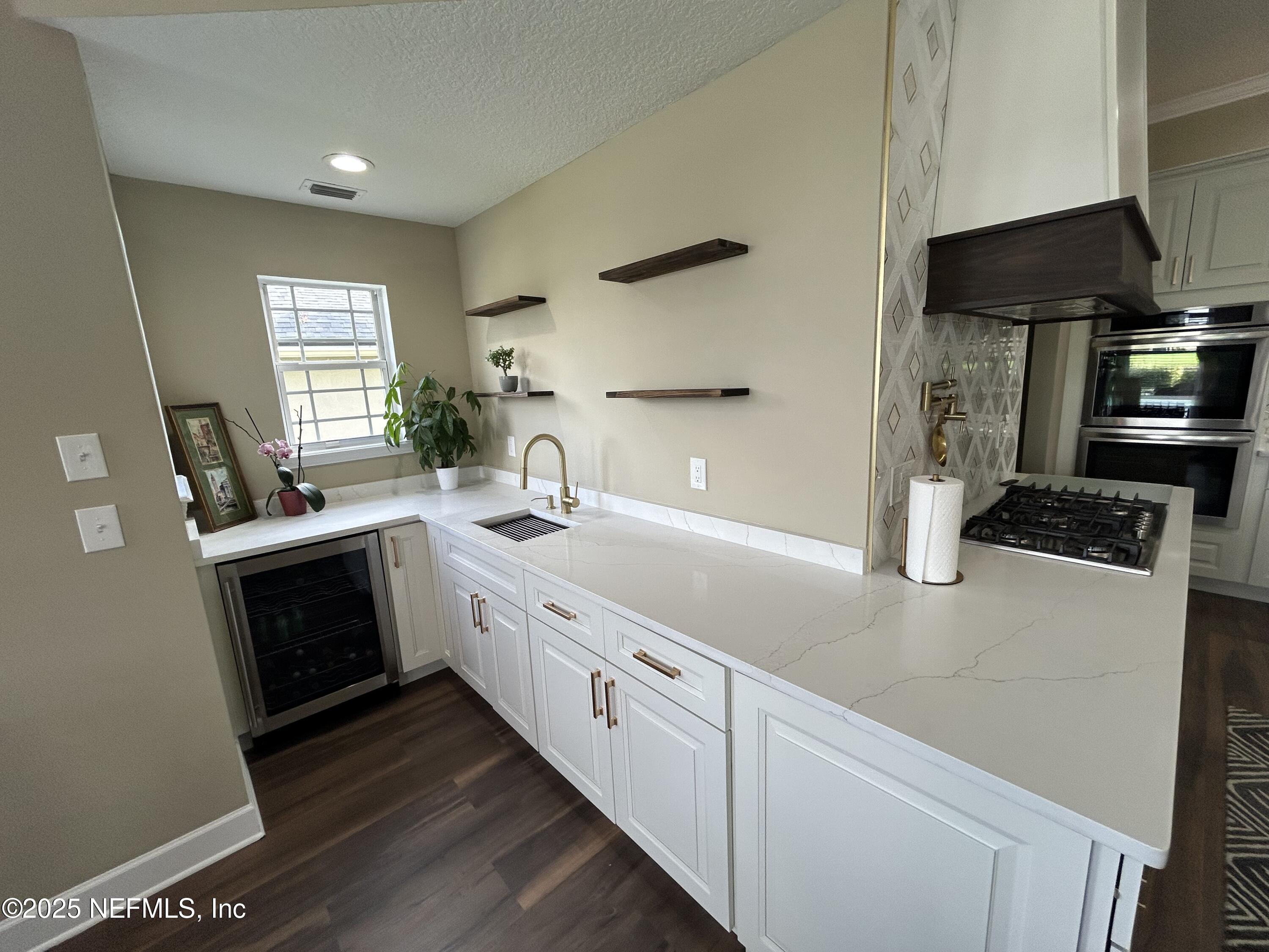 1764 Eagle Watch Drive Fleming Island, FL 32003 - Photo 11 of 41 a kitchen with stainless steel appliances white cabinets and a stove top oven
