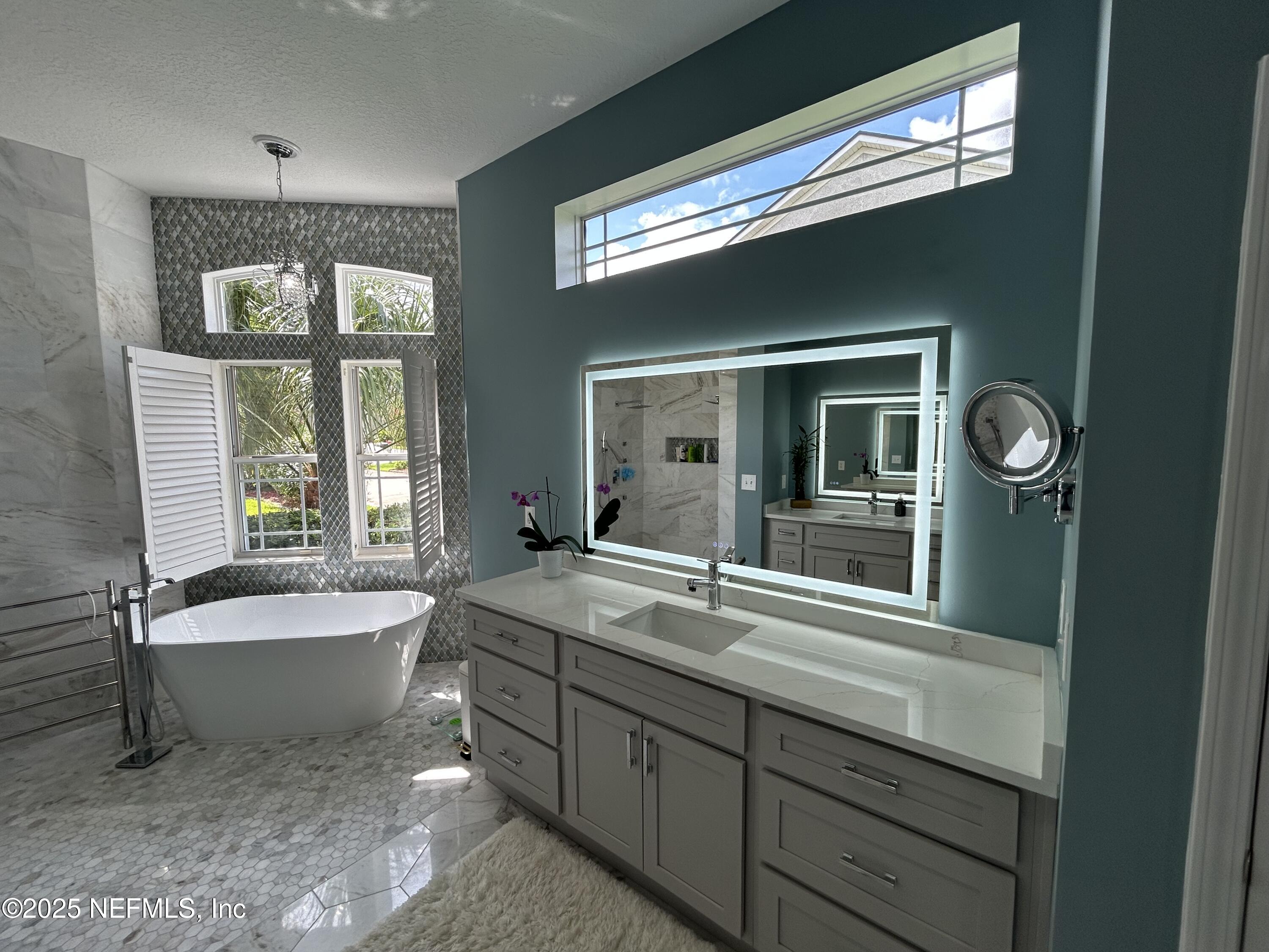 1764 Eagle Watch Drive Fleming Island, FL 32003 - Photo 23 of 41 a bathroom with a sink mirror and a bathtub