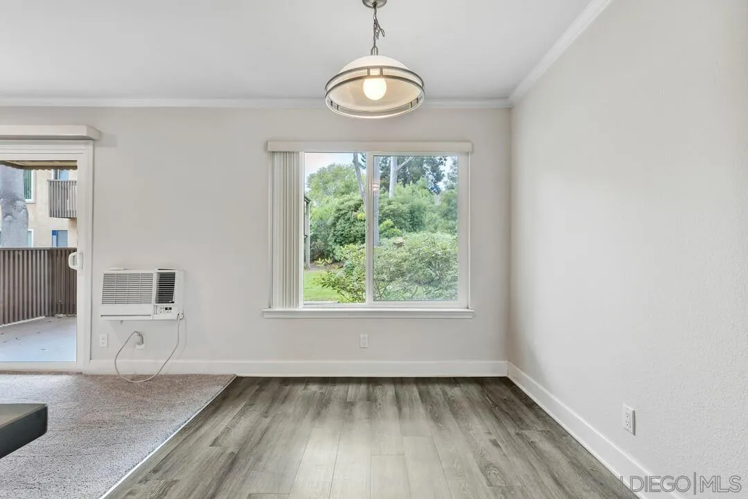 8541 Villa La Jolla Drive, Unit E La Jolla, CA 92037 - Photo 12 of 25 an empty room with wooden floor and windows