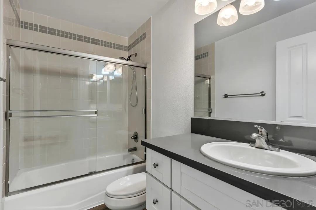 8541 Villa La Jolla Drive, Unit E La Jolla, CA 92037 - Photo 14 of 25 a bathroom with a sink a toilet and a large mirror