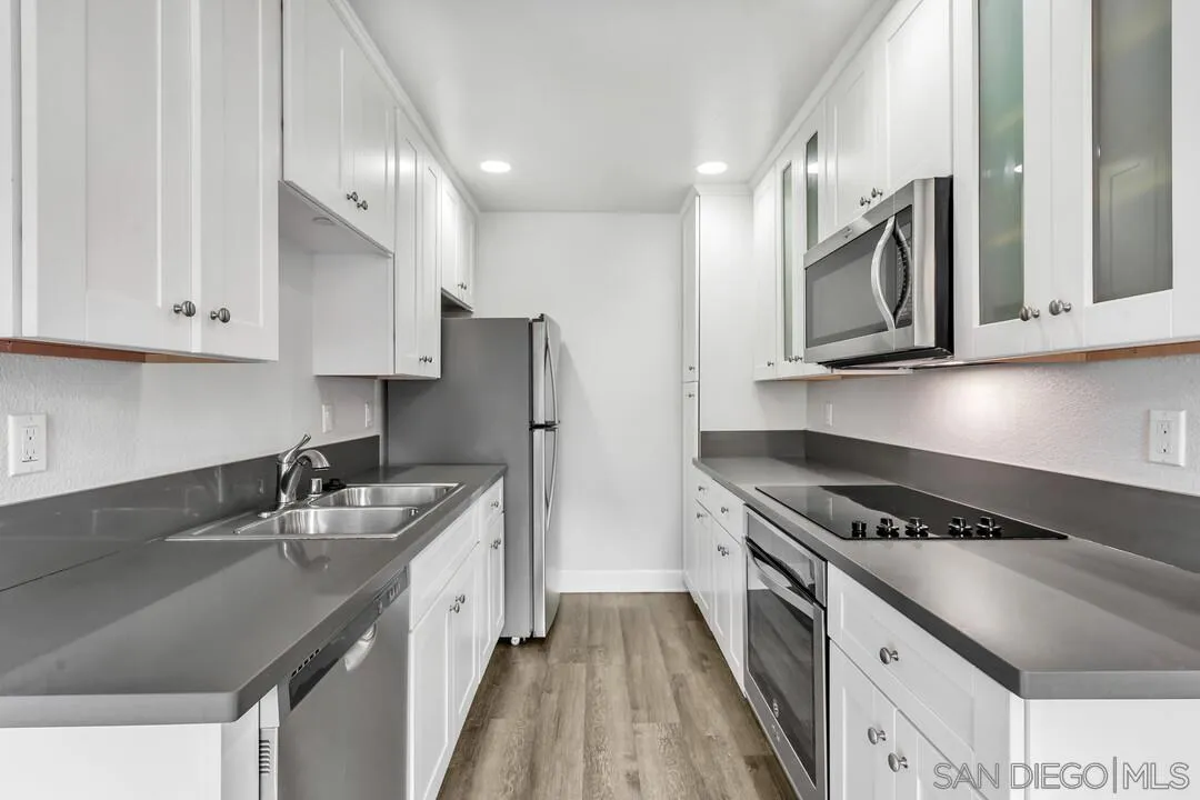 8541 Villa La Jolla Drive, Unit E La Jolla, CA 92037 - Photo 4 of 25 a kitchen with stainless steel appliances granite countertop a sink stove and refrigerator