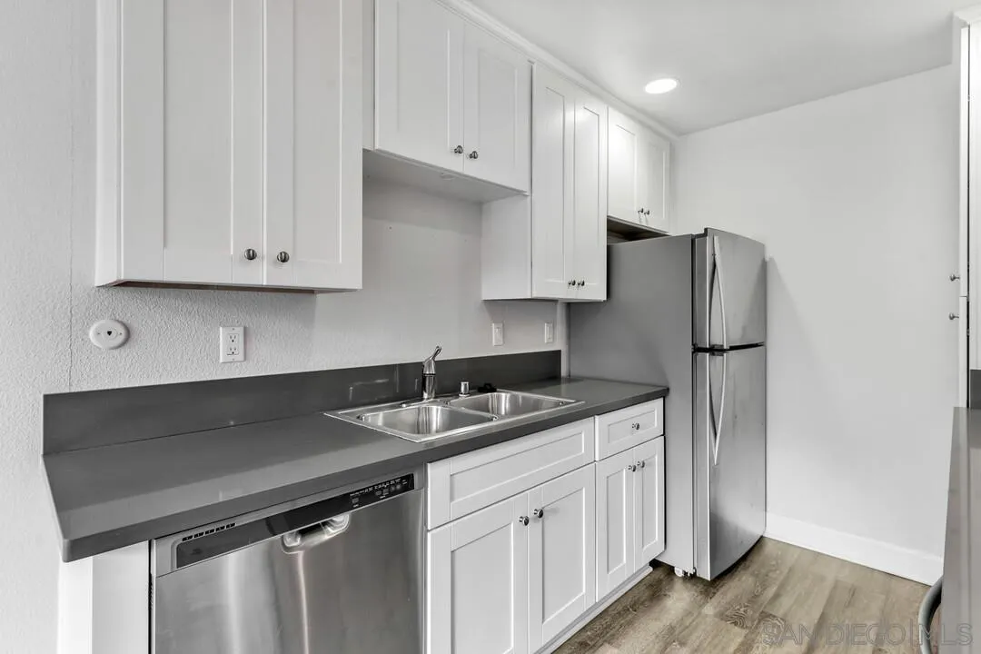 8541 Villa La Jolla Drive, Unit E La Jolla, CA 92037 - Photo 5 of 25 a kitchen with stainless steel appliances granite countertop a sink stove and refrigerator
