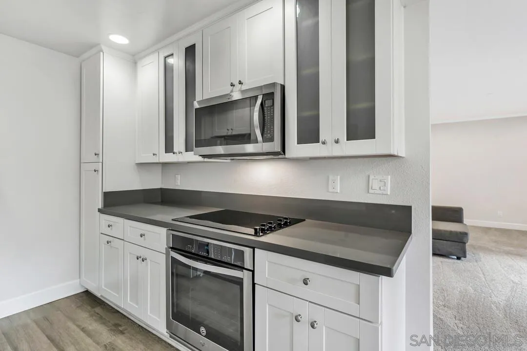 8541 Villa La Jolla Drive, Unit E La Jolla, CA 92037 - Photo 6 of 25 a kitchen with granite countertop white cabinets and stainless steel appliances