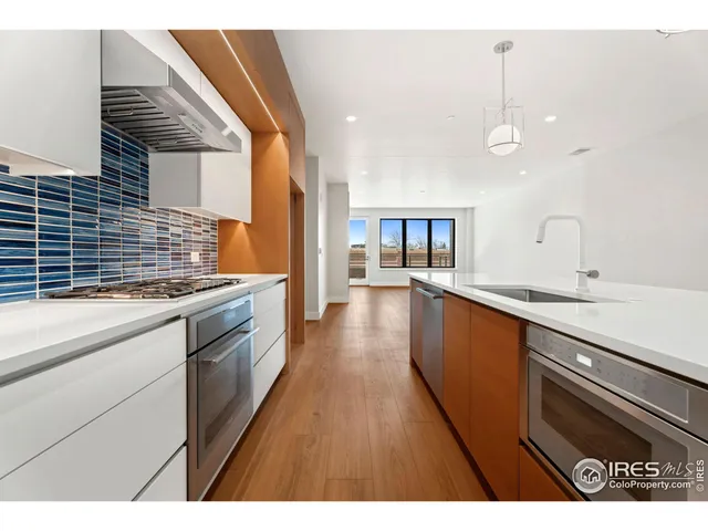 a kitchen with stainless steel appliances kitchen island granite countertop a sink stove and wooden floor