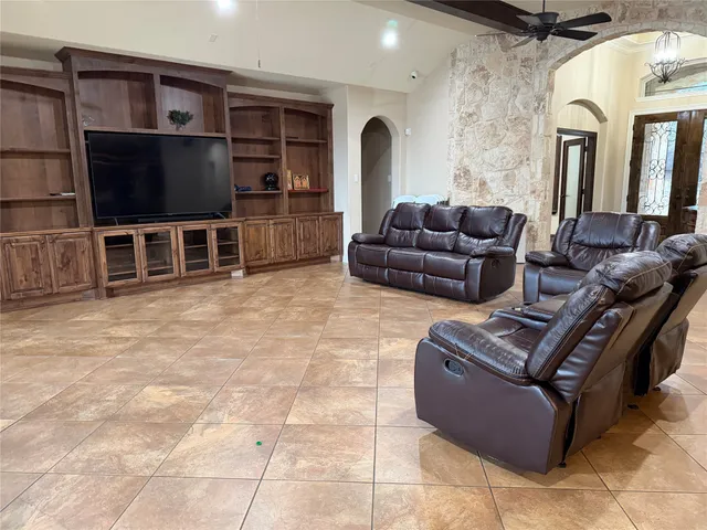 a living room with furniture a flat screen tv and kitchen view