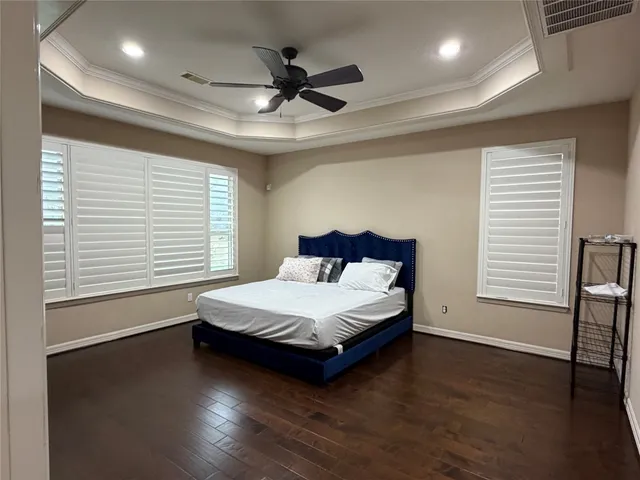 a spacious bedroom with a bed and a large window