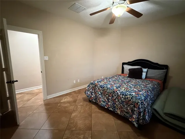 a bedroom with a bed and a ceiling fan