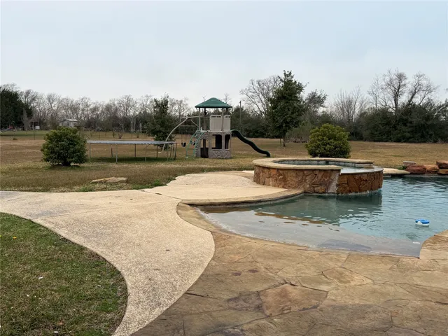 a view of a swimming pool with a yard