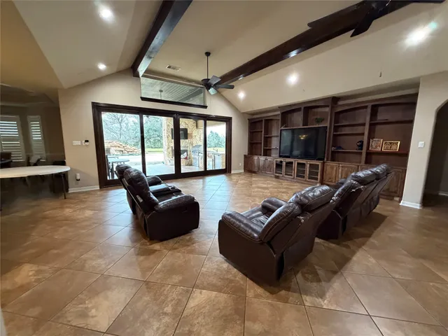 a living room with furniture a ceiling fan and a large window
