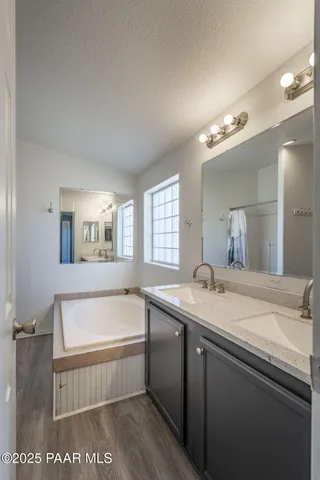 a bathroom with a tub a sink and mirror