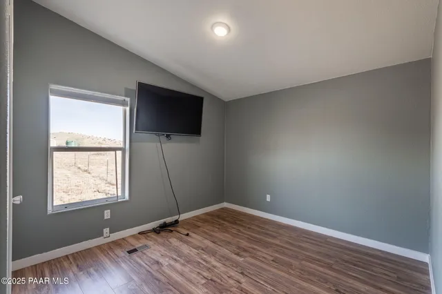 a view of a livingroom with wooden floor and a window