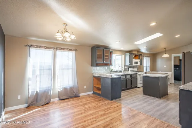a view of kitchen with granite countertop cabinets table and chairs