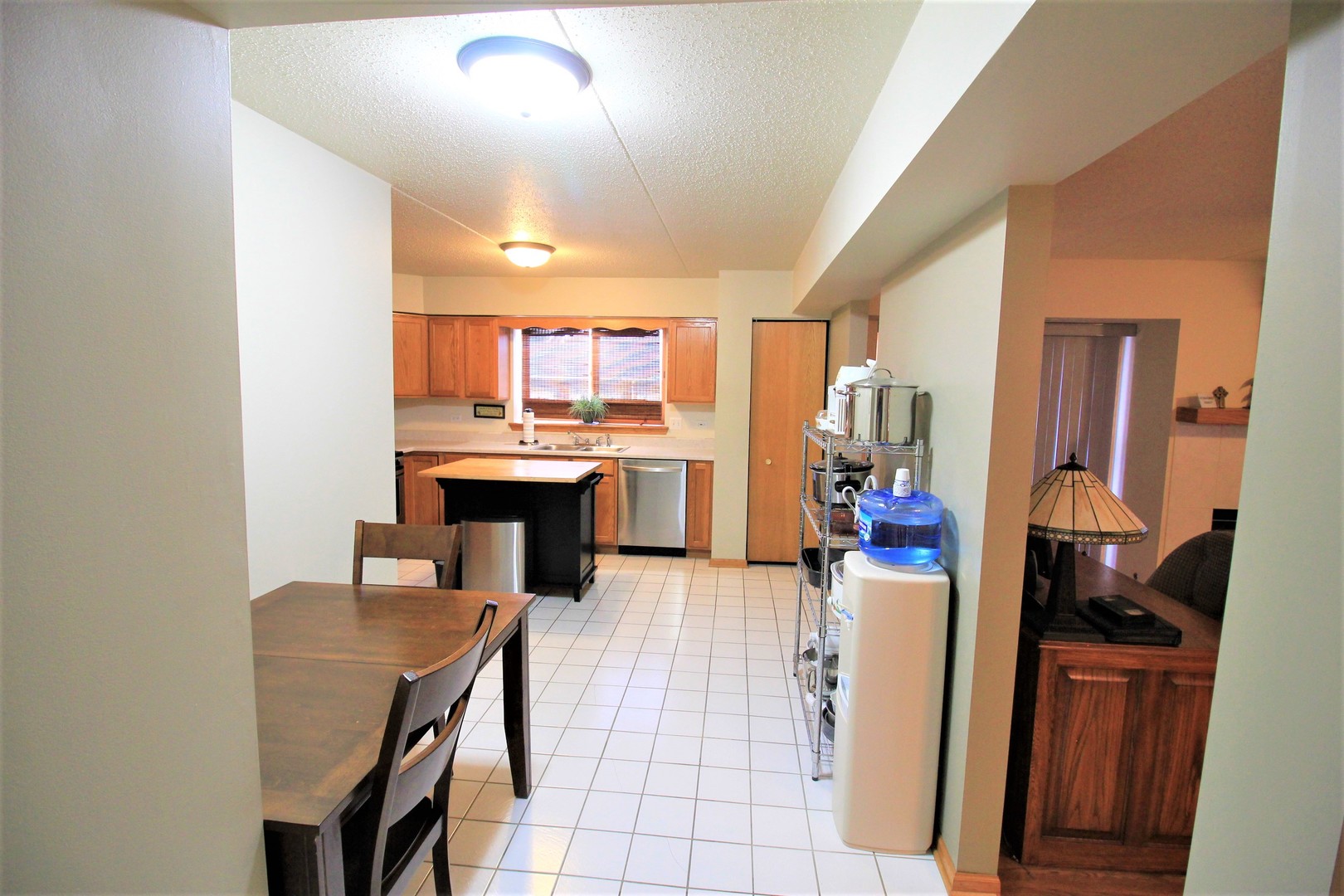18136 Rita Road, Unit 1A Tinley Park, IL 60477 - Photo 17 of 19 a kitchen with stainless steel appliances kitchen island granite countertop a stove refrigerator and cabinets
