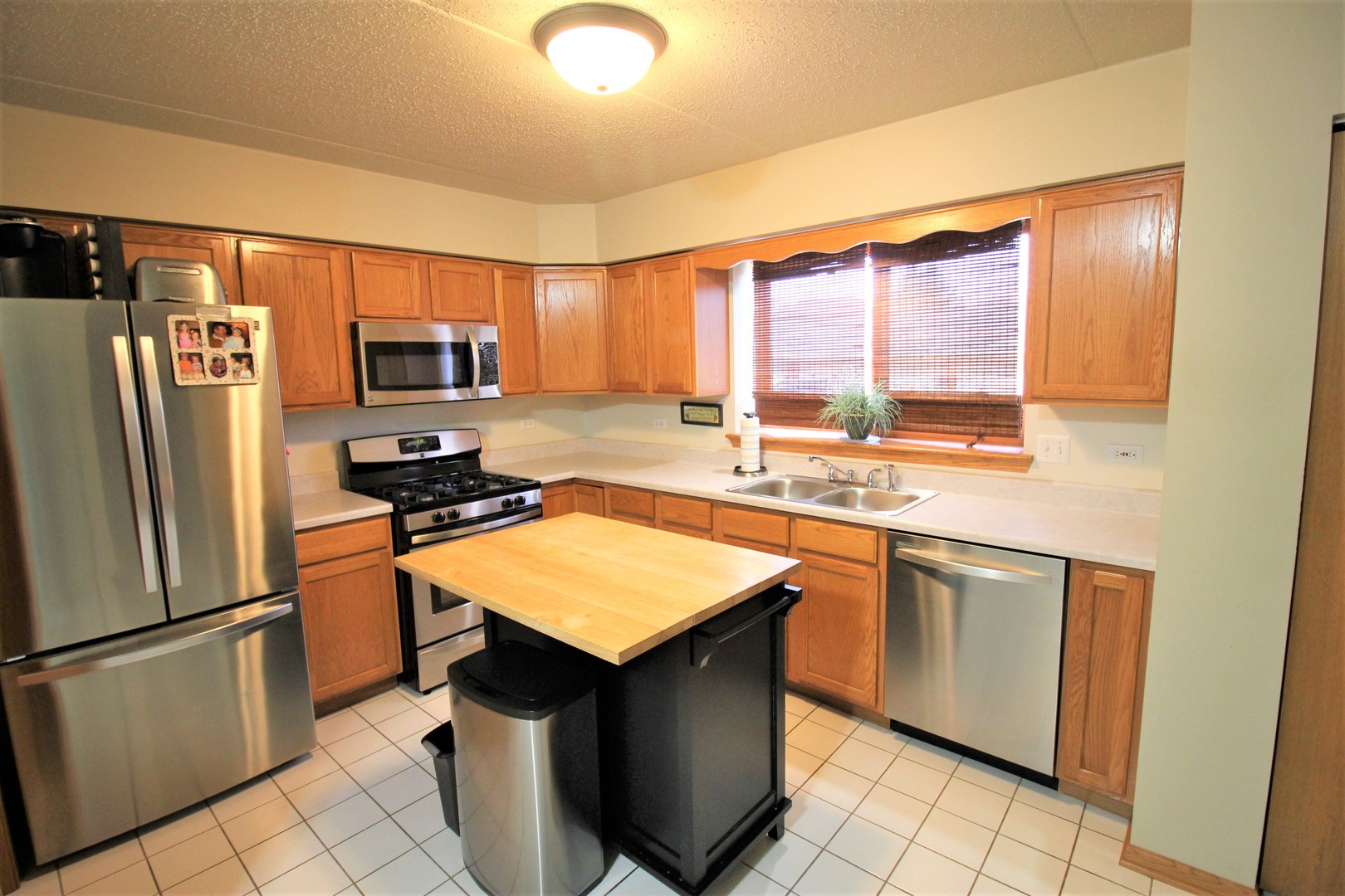 18136 Rita Road, Unit 1A Tinley Park, IL 60477 - Photo 3 of 19 a kitchen with stainless steel appliances granite countertop a sink stove refrigerator and a window