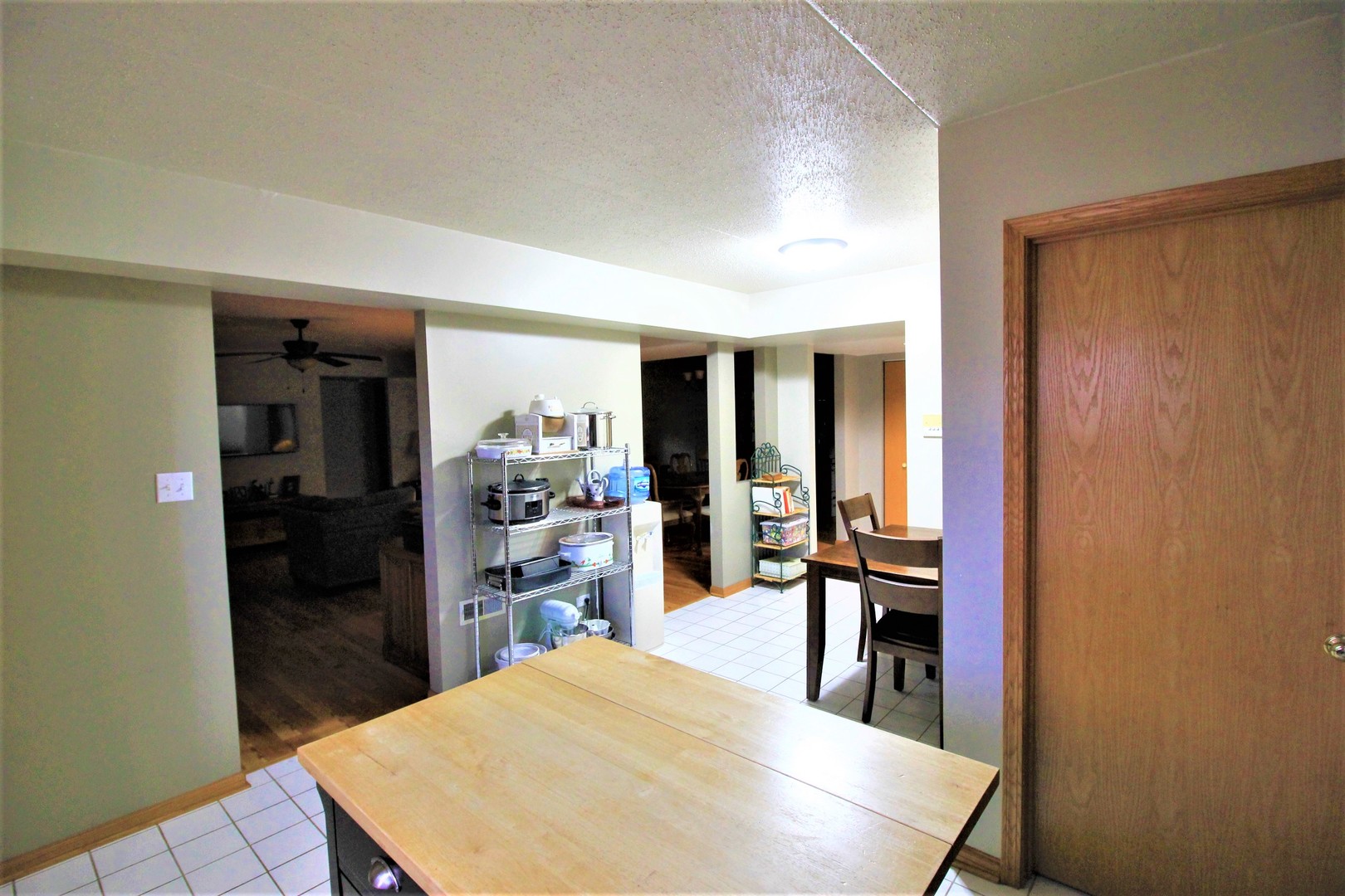 18136 Rita Road, Unit 1A Tinley Park, IL 60477 - Photo 4 of 19 a kitchen with stainless steel appliances kitchen island granite countertop dining table chairs and granite counter top