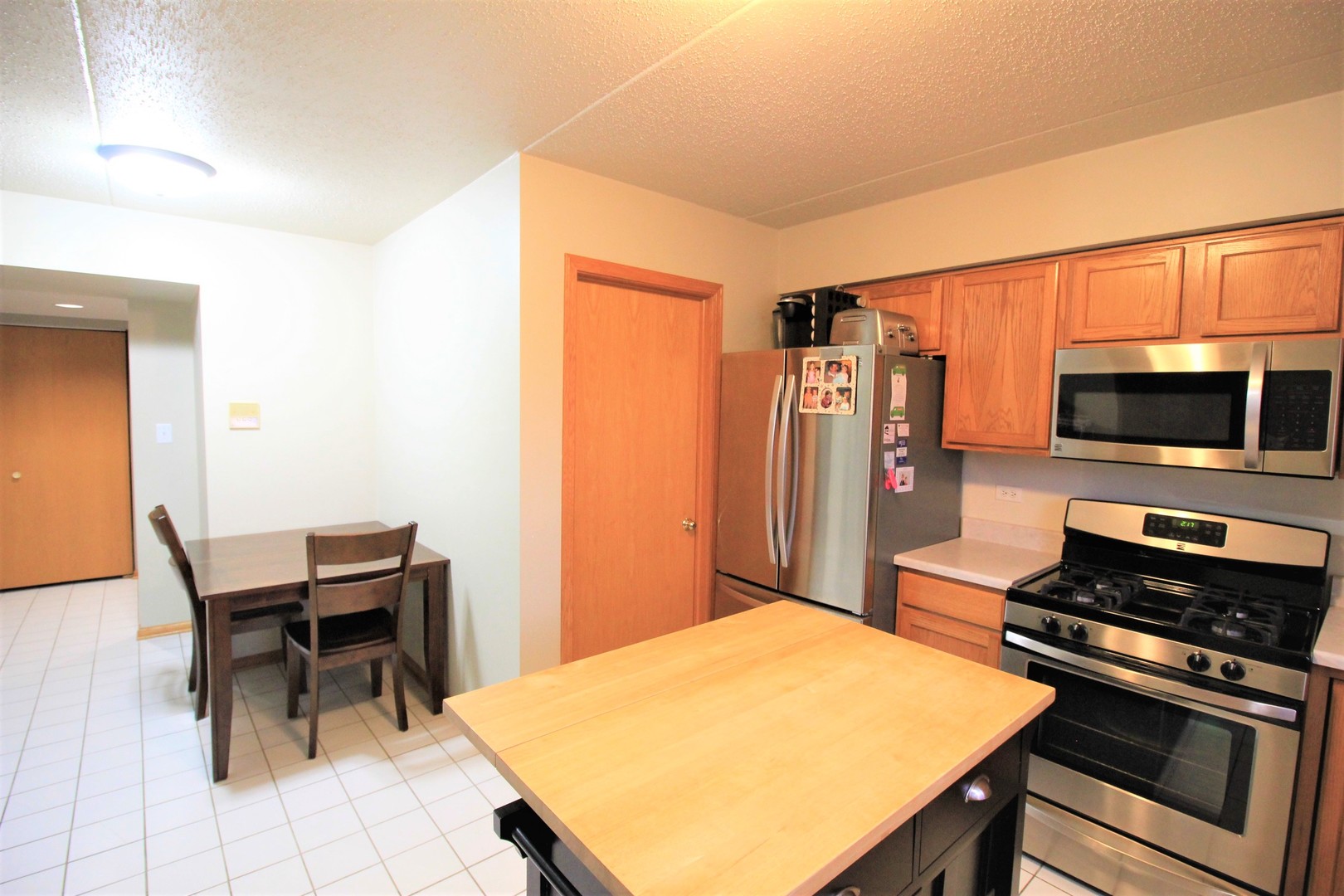 18136 Rita Road, Unit 1A Tinley Park, IL 60477 - Photo 5 of 19 a kitchen with a stove and a microwave