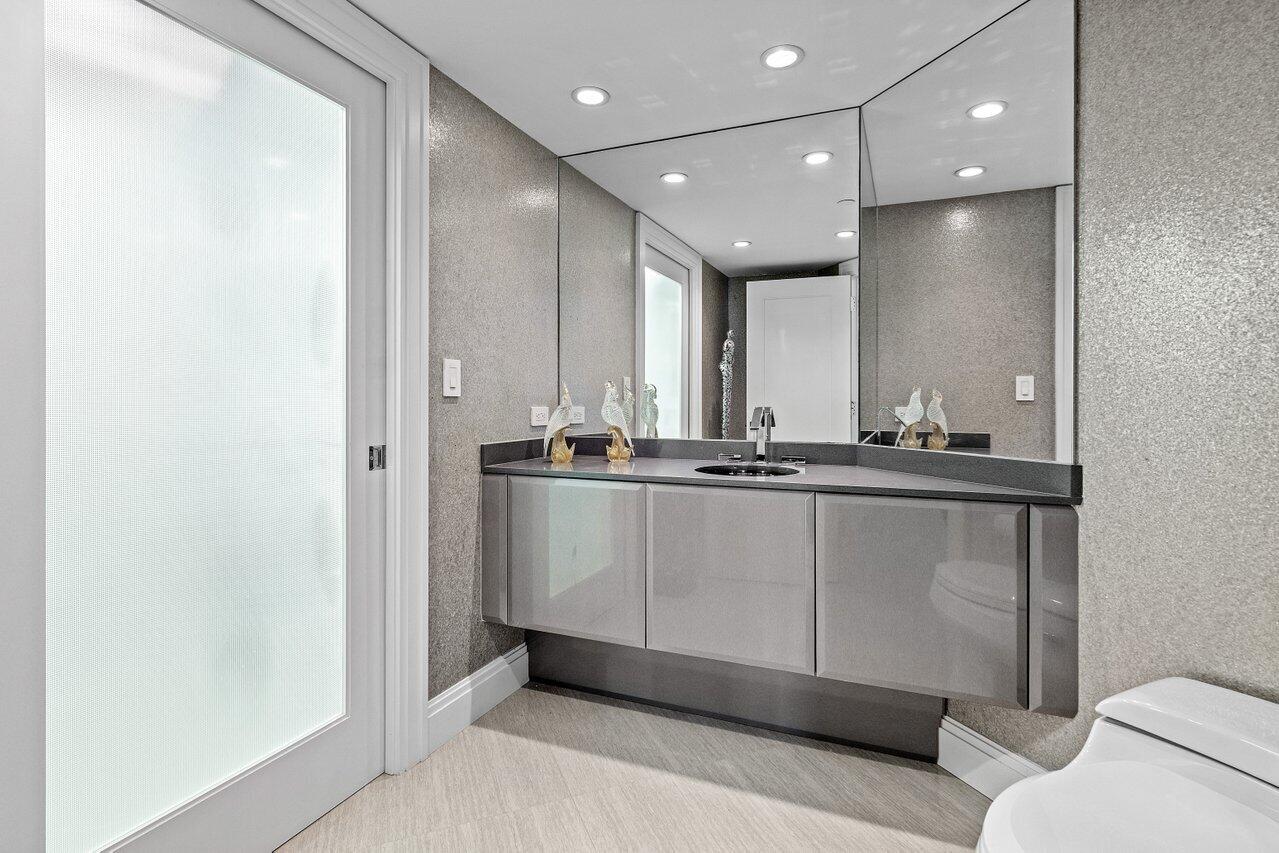 4545 North Ocean Boulevard, Unit 18D Boca Raton, FL 33431 - Photo 14 of 28 a bathroom with a sink a mirror and a toilet