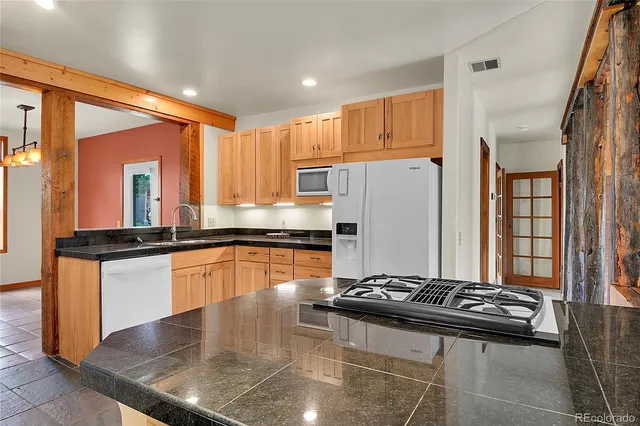 a kitchen with stainless steel appliances granite countertop a stove a refrigerator and a refrigerator
