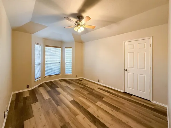 a view of an empty room with a chandelier fan