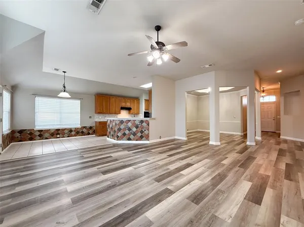 a view of a livingroom with a dinning area chandelier and a ceiling fan