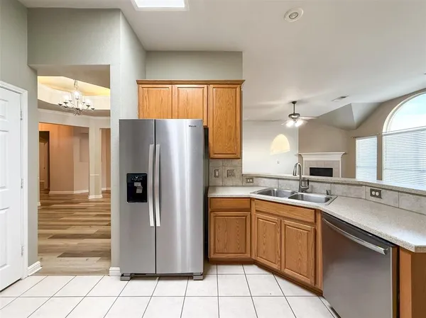 a kitchen with a sink a refrigerator and cabinets