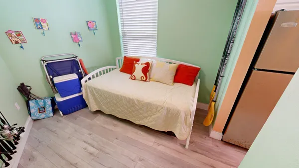 a bedroom with a bed and wooden floor