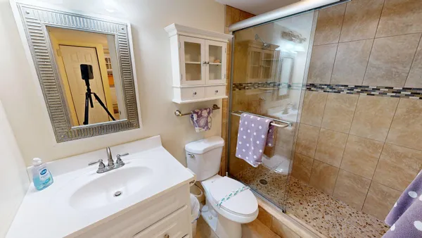 a bathroom with a double vanity sink mirror and shower