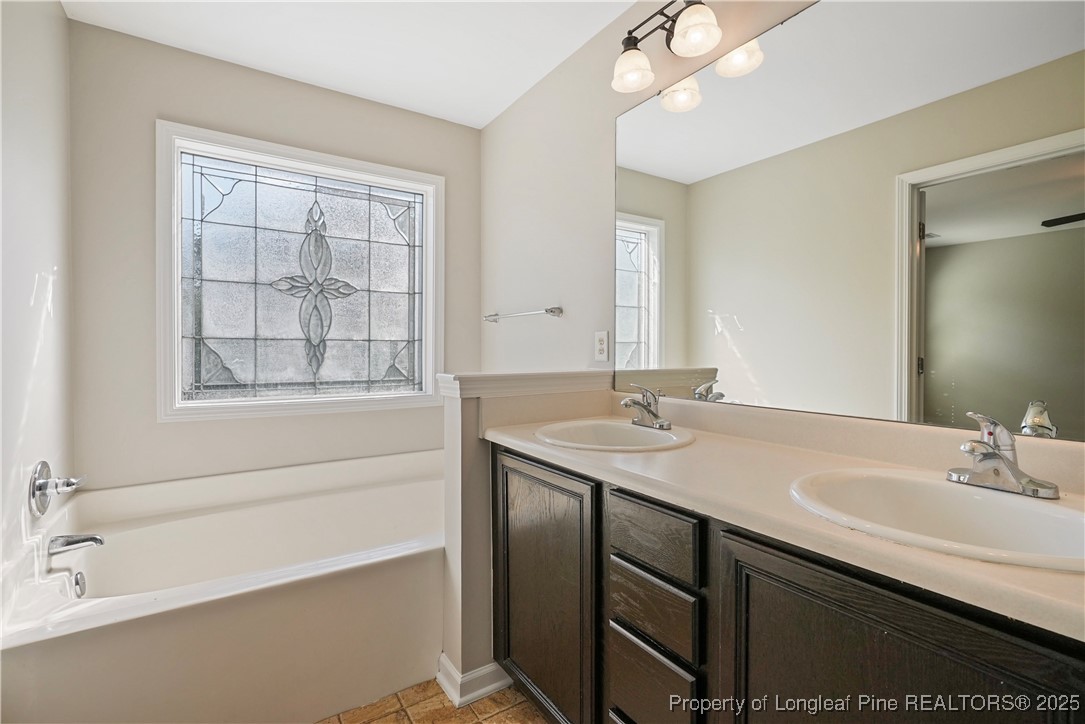 720 Cape Fear Road Raeford, NC 28376 - Photo 25 of 35 a bathroom with a sink double vanity granite tub shower and a mirror