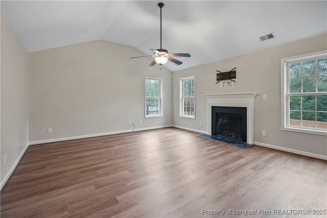 720 Cape Fear Road Raeford, NC 28376 - Photo 6 of 35 a view of empty room with wooden floor fireplace and a window