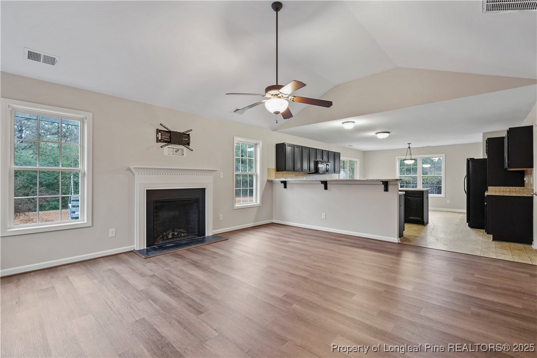 720 Cape Fear Road Raeford, NC 28376 - Photo 8 of 35 a view of a kitchen with furniture a ceiling fan and wooden floor