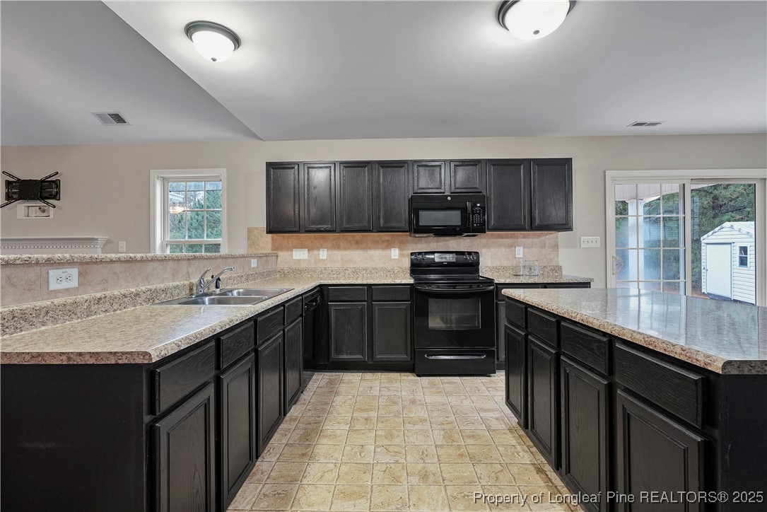 720 Cape Fear Road Raeford, NC 28376 - Photo 10 of 35 a kitchen with stainless steel appliances granite countertop a sink stove and refrigerator