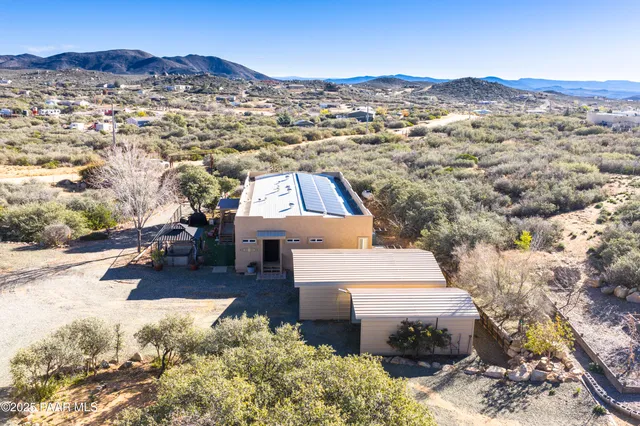 an aerial view of residential houses with outdoor space and trees