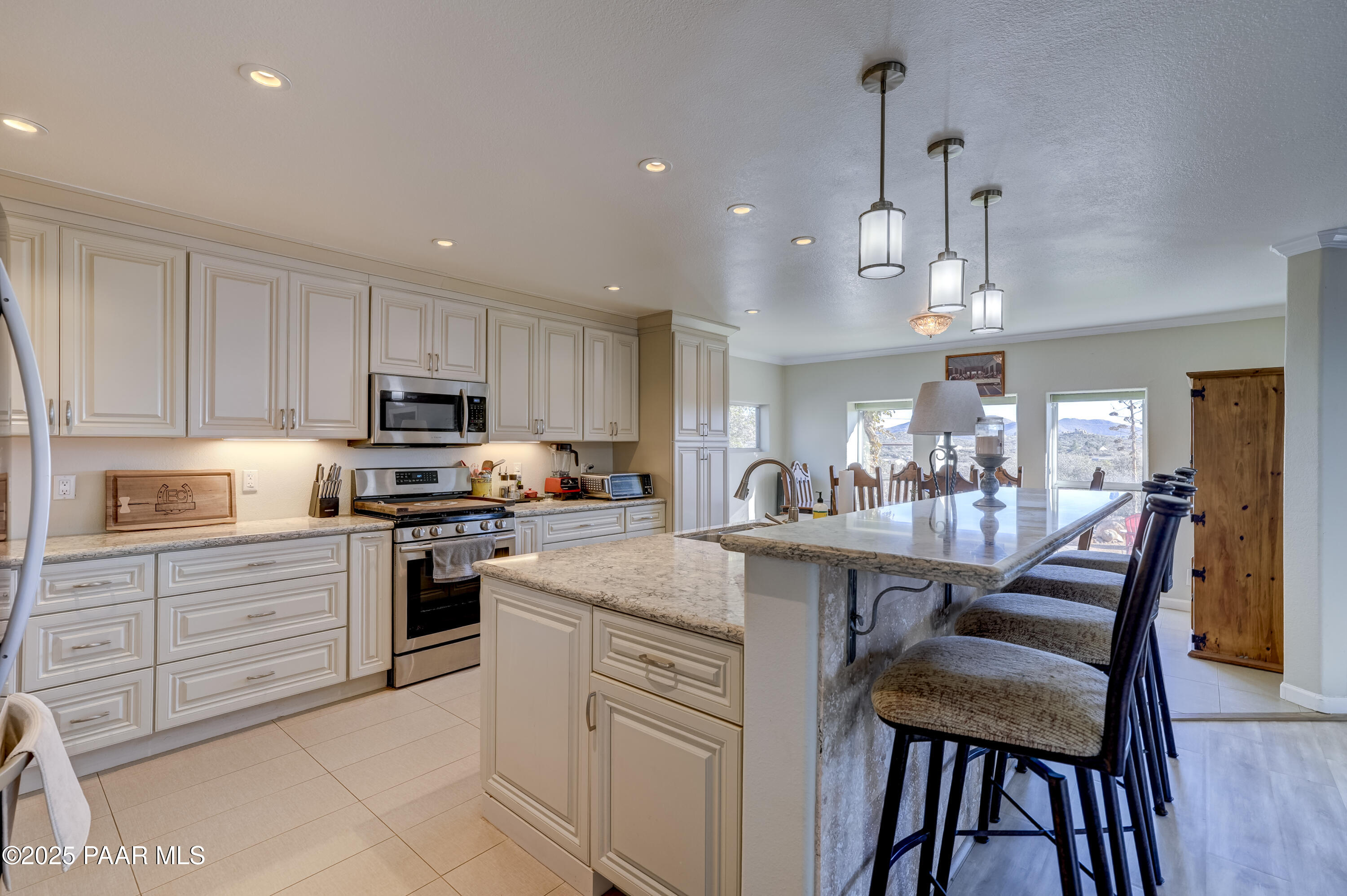 760 Yarber Wash Road Dewey, AZ 86327 - Photo 6 of 66 a kitchen with stainless steel appliances kitchen island granite countertop a table chairs and a refrigerator