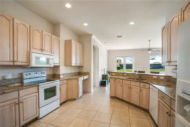 a kitchen with a sink stove top oven and cabinets