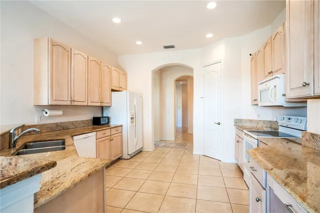 a kitchen with stainless steel appliances granite countertop a refrigerator sink and cabinets